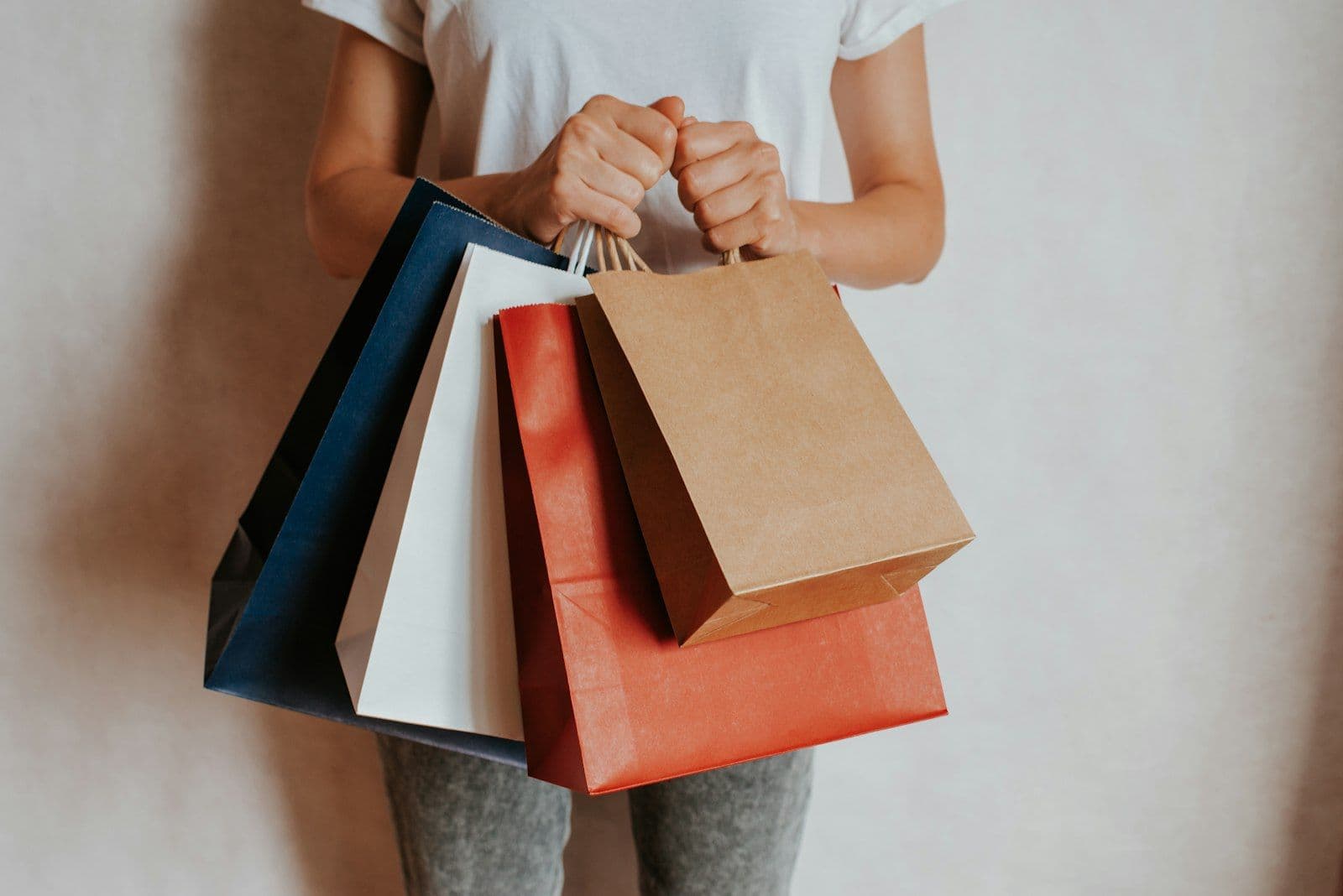 Persona sosteniendo bolsas de compra de papel